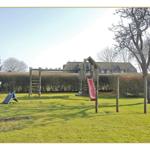 Großer Garten mit Spielplatz, Rutsche und Klettergerüst. Hinterhof mit Hecke und Bäumen.