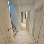 Flur mit Holzboden, Treppe und Türen zu verschiedenen Räumen.