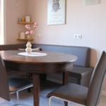 Runde Holztisch mit Stühlen und Sitzbank an der Wand