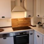 Küche mit Induktionskochfeld, Backofen und Spülmaschine.