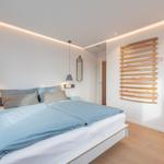Schlafzimmer mit Bett, Kleiderständer und Schrank.