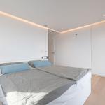 Schlafzimmer mit Doppelbett, Kleiderschrank und Holzboden.