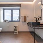 Badezimmer mit Dusche, Waschbecken und Fenster mit Blick.