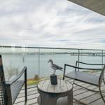 Terrasse mit Meeresblick, zwei Stühlen und einer Möwe auf Tisch