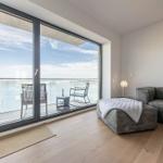 Wohnzimmer mit Balkon und Meerblick. Sofa, Sessel und Tisch sind vorhanden.