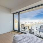 Schlafzimmer mit Balkon und Blick auf Wasser