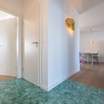 Flur mit grünem Fliesenboden, Tür zu Schlafzimmer und Essbereich mit Kühlgerät.