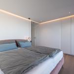 Schlafzimmer mit Bett, Kleiderschrank und Hängelampen.