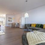 Wohnbereich mit Sofa, Kamin und Essbereich im Hintergrund.