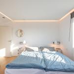 Schlafzimmer mit Bett, Fenster und Kleiderständer