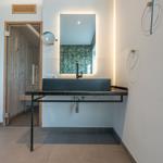 Waschbecken mit Spiegel und Handtuchhalter in moderner Badezimmerausstattung.