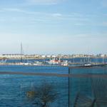 Blick auf Hafen mit Booten und gegenüberliegenden Gebäuden.