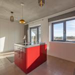 Küche mit rotem Inselblock und Fensterblick