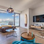 Wohnzimmer mit Meerblick, Sofa, Couchtisch und Fernseher.
