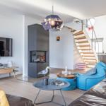 Wohnzimmer mit TV, Kamin und blauem Sitzmöbel
