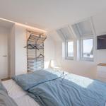 Schlafzimmer mit Dachfenster, Bett und Kleiderschrank.