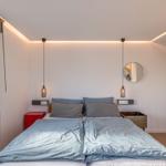 Schlafzimmer mit Doppelbett, Fenster und zwei Hängelampen.