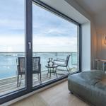 Wohnzimmer mit Balkonblick auf Hafen und Wasser.