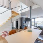 Moderne Küche mit Essbereich und Treppe zur oberen Etage.