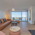 Wohnzimmer mit Sofa, Couchtisch und Blick auf Hafen.