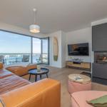 Wohnzimmer mit Blick auf Hafen, Sofa, Kamin und TV