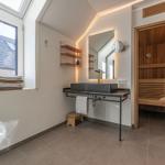 Badezimmer mit Sauna, Waschtisch und Fenster