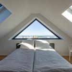 Schlafzimmer mit Dachfenster und Blick auf Hafen