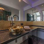 Bad mit goldenem Waschbecken und Spiegelwand