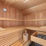 Sauna mit Holzbanken, Thermometer und Steinmulde.