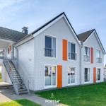 Zweistöckiges Haus mit orangefarbenen Akzenten und Balkonen.