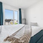 Schlafzimmer mit Bett, Fenster und Wandbild