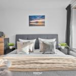 Schlafzimmer mit Bett, Fenster und Wandbild