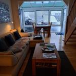 Living and dining area with wooden furniture and glass roof