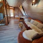 Living area with sofa, table, and sleeping space under sloped ceiling