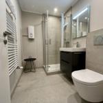 Moderne Badezimmer mit Dusche, Waschbecken und Toilette.
