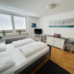 Bedroom with double bed, window, TV, and dresser.