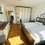 Bedroom with double bed, wardrobe, and hardwood floor.