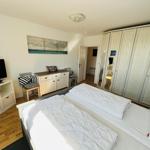 Bedroom with double bed, wardrobe, and TV.