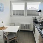 Kitchen with dining table, windows, and kitchen appliances.
