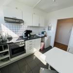 Kitchen with white cabinets, stove, and dining table