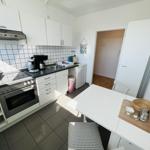 Kitchen with white cabinets, countertop, and dining table.