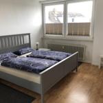 Bedroom with double bed, window, and wooden floor.