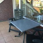 Terrasse mit Tisch und Stühlen, Blick auf Nachbarhäuser.