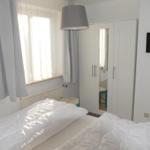 Bedroom with bed, window, wardrobe, and wall-mounted TV.