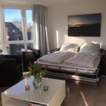 Bedroom with bed, seating, and windows for views.