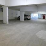 Underground parking lot with one parking space and a red door.