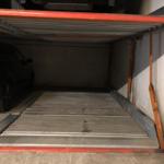 Car parked in a garage with a roll-up door.