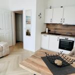 Wohn- und Küchenbereich mit Holzboden und moderner Einbauküche.