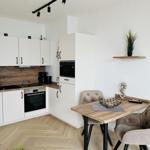 Küche mit Essbereich, weißen Schränken und Holzboden