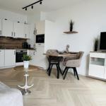 Küche, Essbereich und Wohnbereich mit Holzboden und moderner Einrichtung.